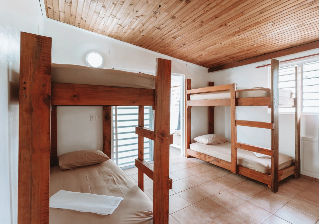 Dortoir : lits superposés en bois massif, carrelage, fenêtres à lames